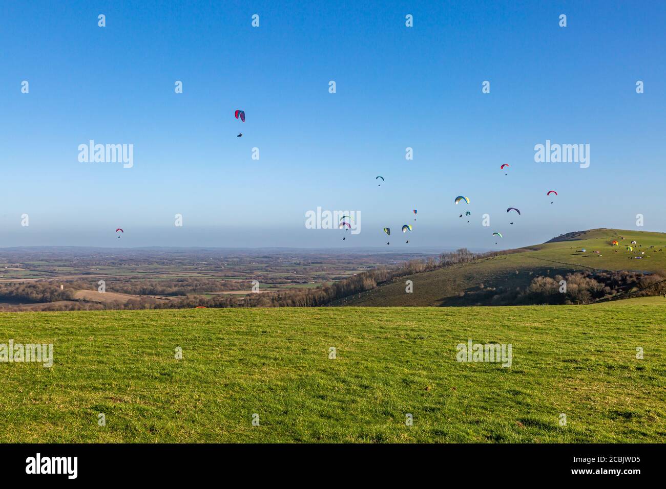 Parapente dans le ciel au-dessus de Firle Beacon dans les South Downs, lors d'une journée hivernale ensoleillée Banque D'Images