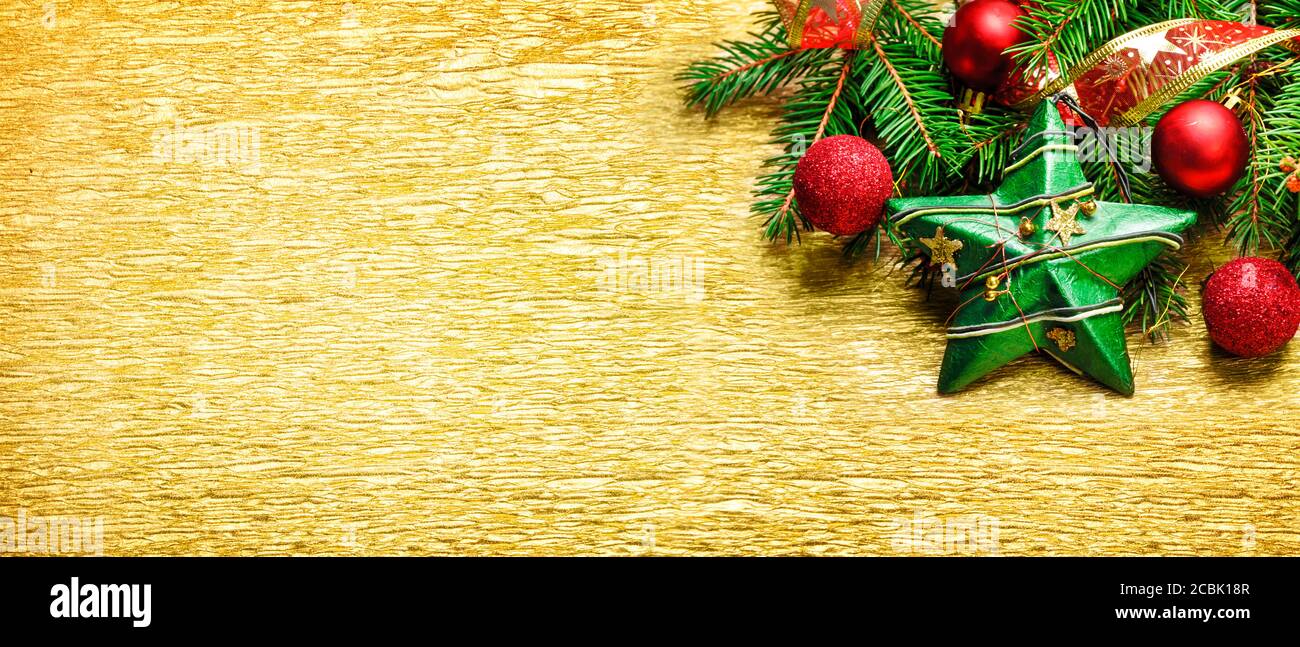 Décoration de Noël et du nouvel an sur fond texturé doré. Banderole de Noël dorée avec décorations de Noël et bordure en sapin. Vue de dessus. Banque D'Images