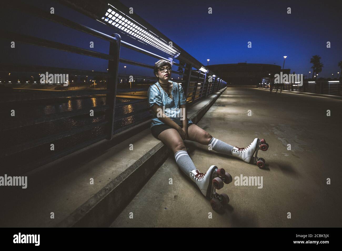 Videos De Femmes A Poil Une belle photo d'une femme à poil court avec patins à roulettes assis sur  le trottoir la nuit sous une lumière Photo Stock - Alamy