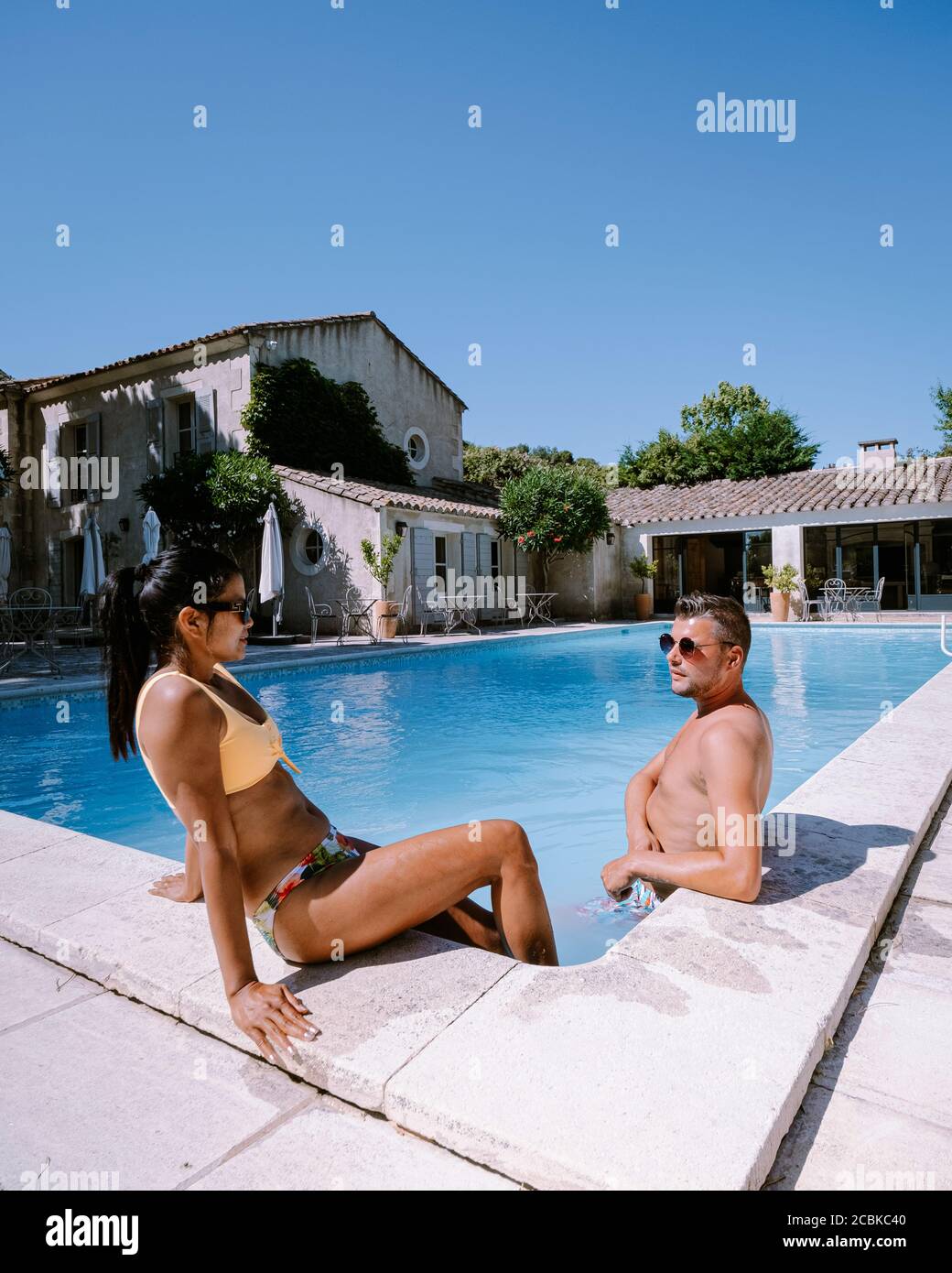 Couple de détente au bord de la piscine en Provence France, hommes et femmes de détente au bord de la piscine dans un complexe de luxe Banque D'Images