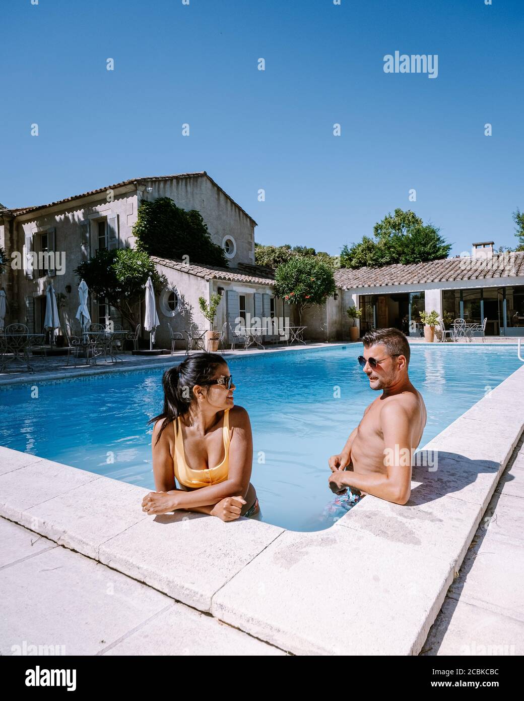 Couple de détente au bord de la piscine en Provence France, hommes et femmes de détente au bord de la piscine dans un complexe de luxe Banque D'Images