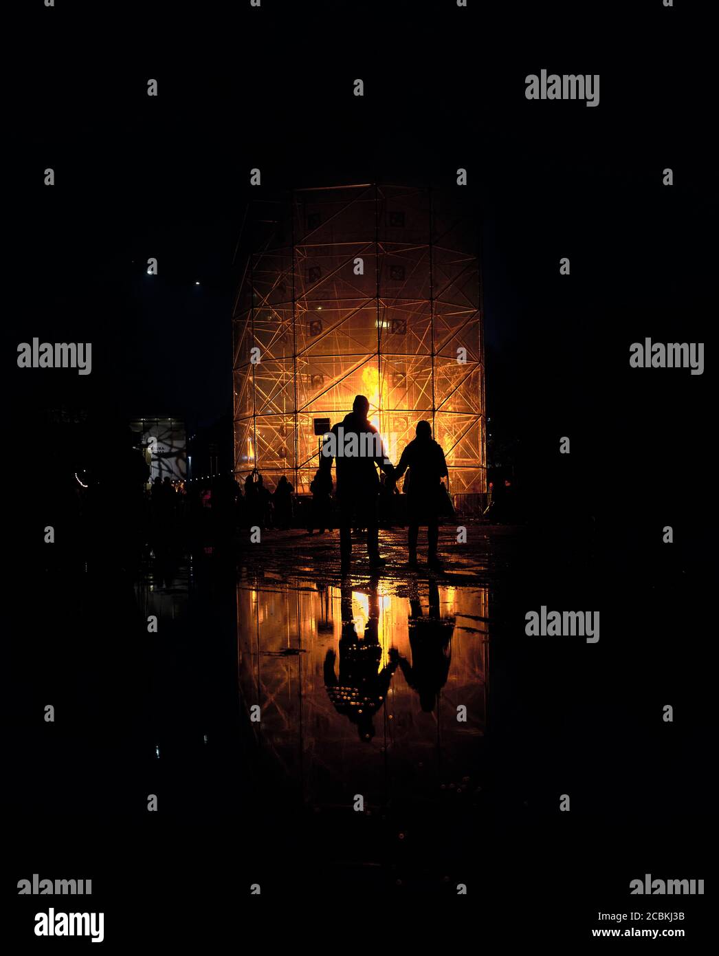 Silhouette de deux personnes regardant l'installation d'art de feu Grand incendie Tornade par Ivo Schoofs au Lux Helsinki 2020 Light festival des arts à Kaisaniemenp Banque D'Images