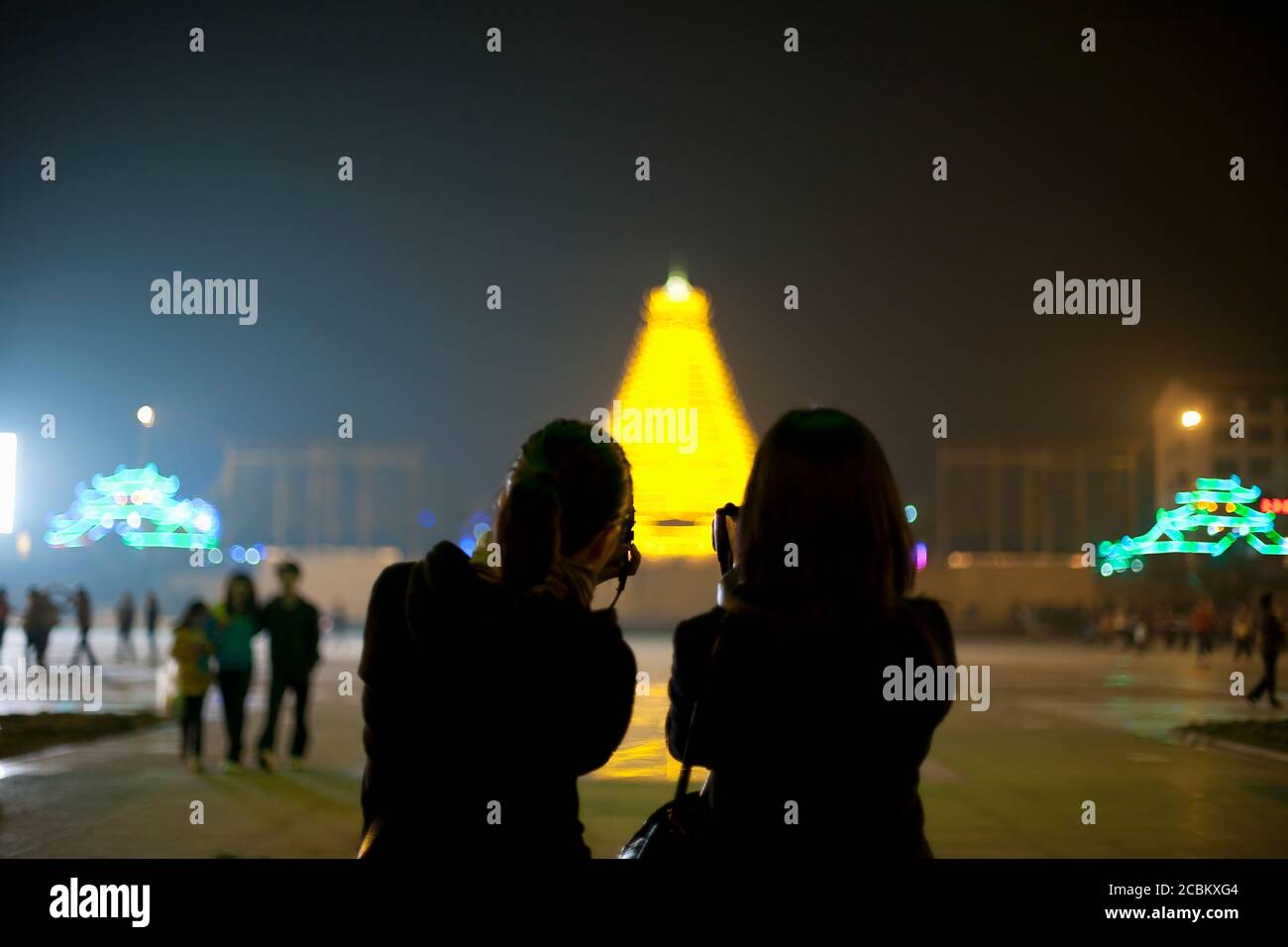 Deux touristes chinois prenant des photos de la pagode illuminée dans le centre de Sanjiang, Guangxi Provence, Chine Banque D'Images
