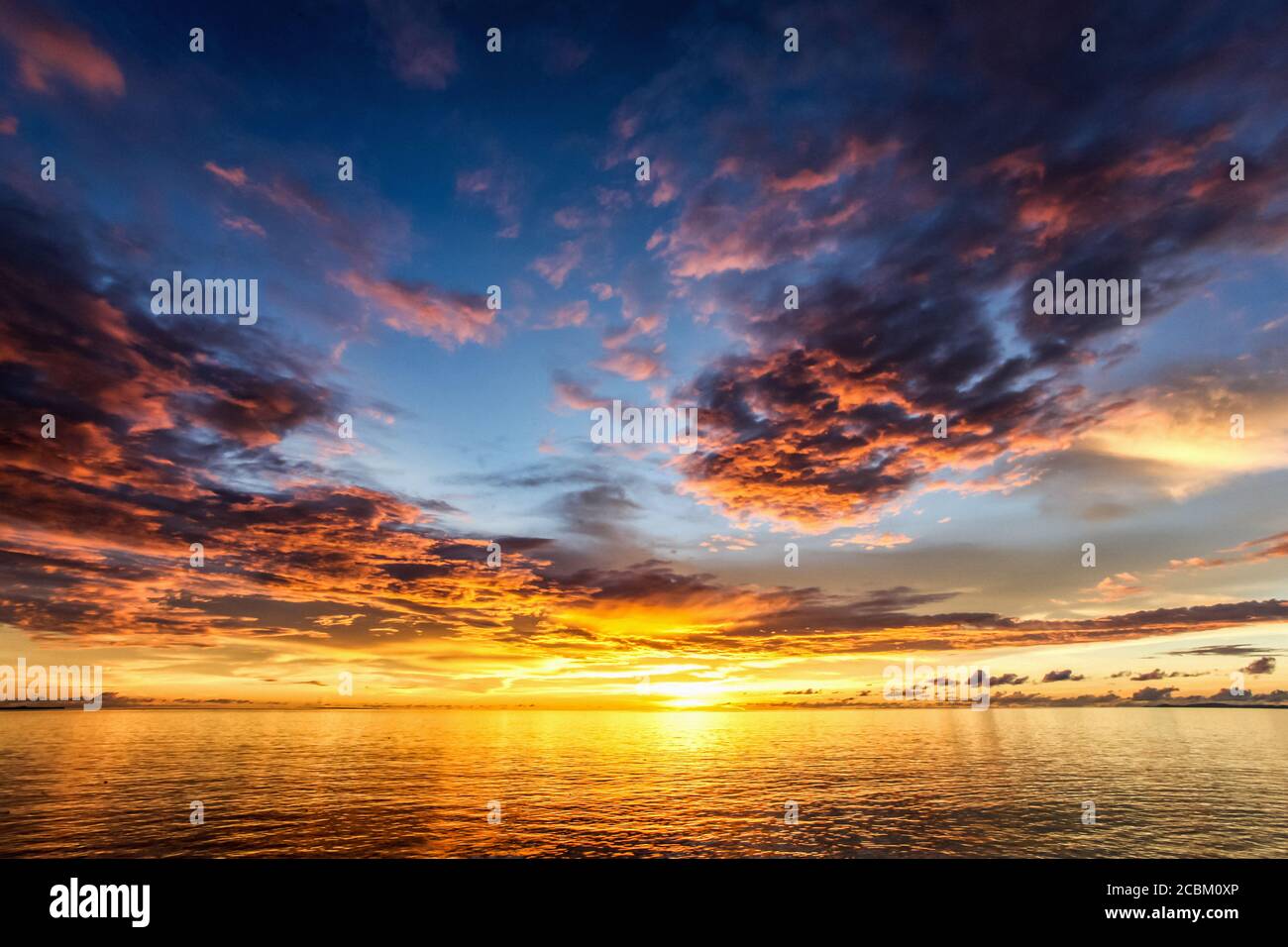 Coucher de soleil sur l'équateur dans les îles Raja Ampat de la Papouasie occidentale dans la mer de Halmahera, Papouasie occidentale, Indonésie Banque D'Images