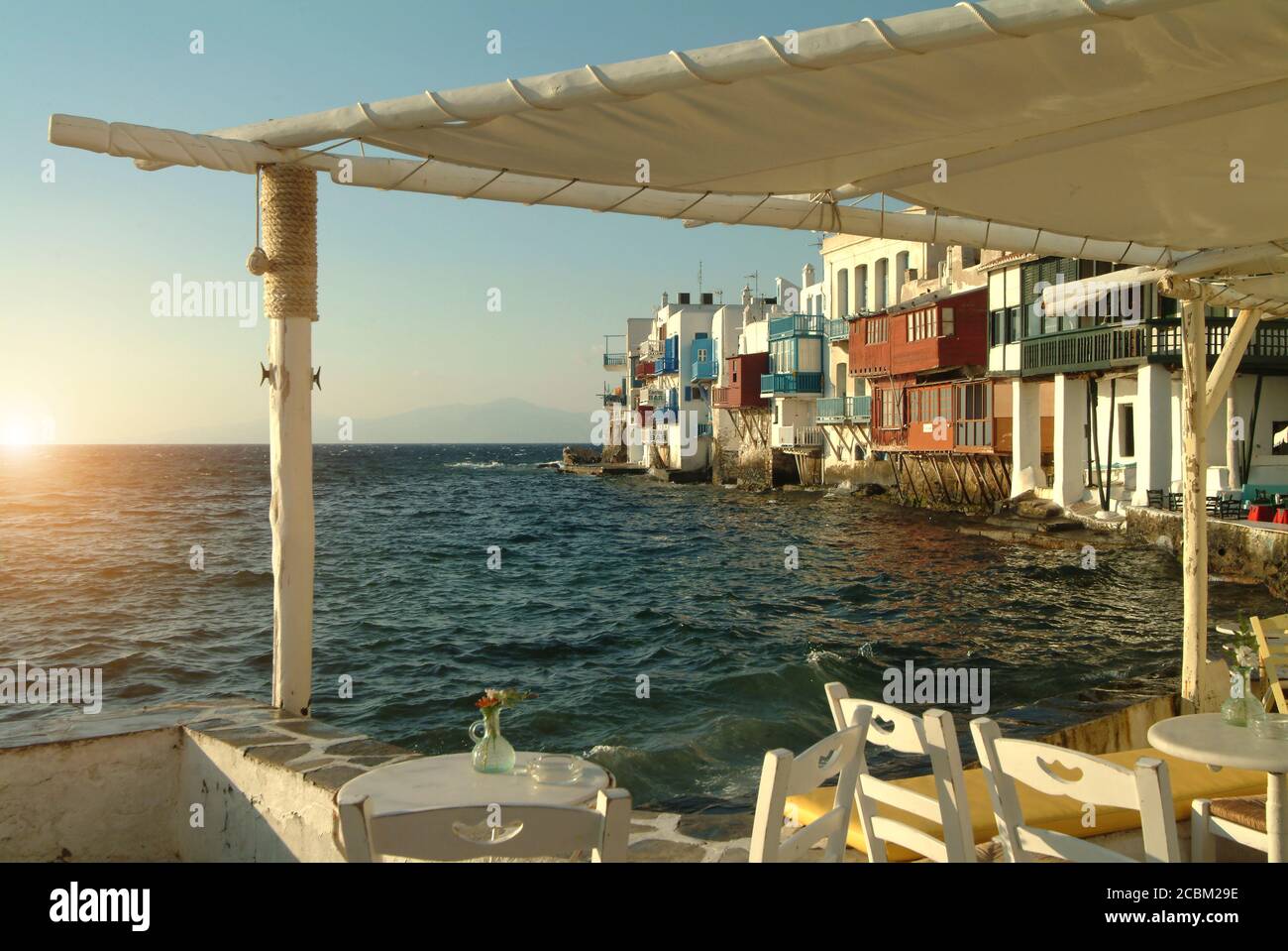 Vue sur le soleil depuis le restaurant côtier, Mykonos, Cyclades, Grèce Banque D'Images