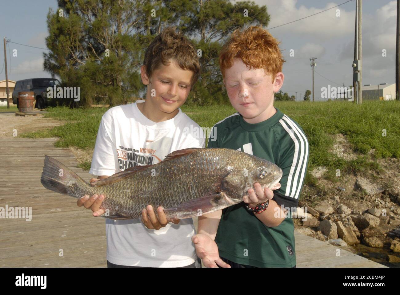 Port Mansfield, Texas, le 12 juillet 2006 : des garçons de 10 ans avec leur prise d'un tambour noir de six livres pris sur la côte sud du Texas lors d'un voyage de pêche en été. ©Bob Daemmrich Banque D'Images