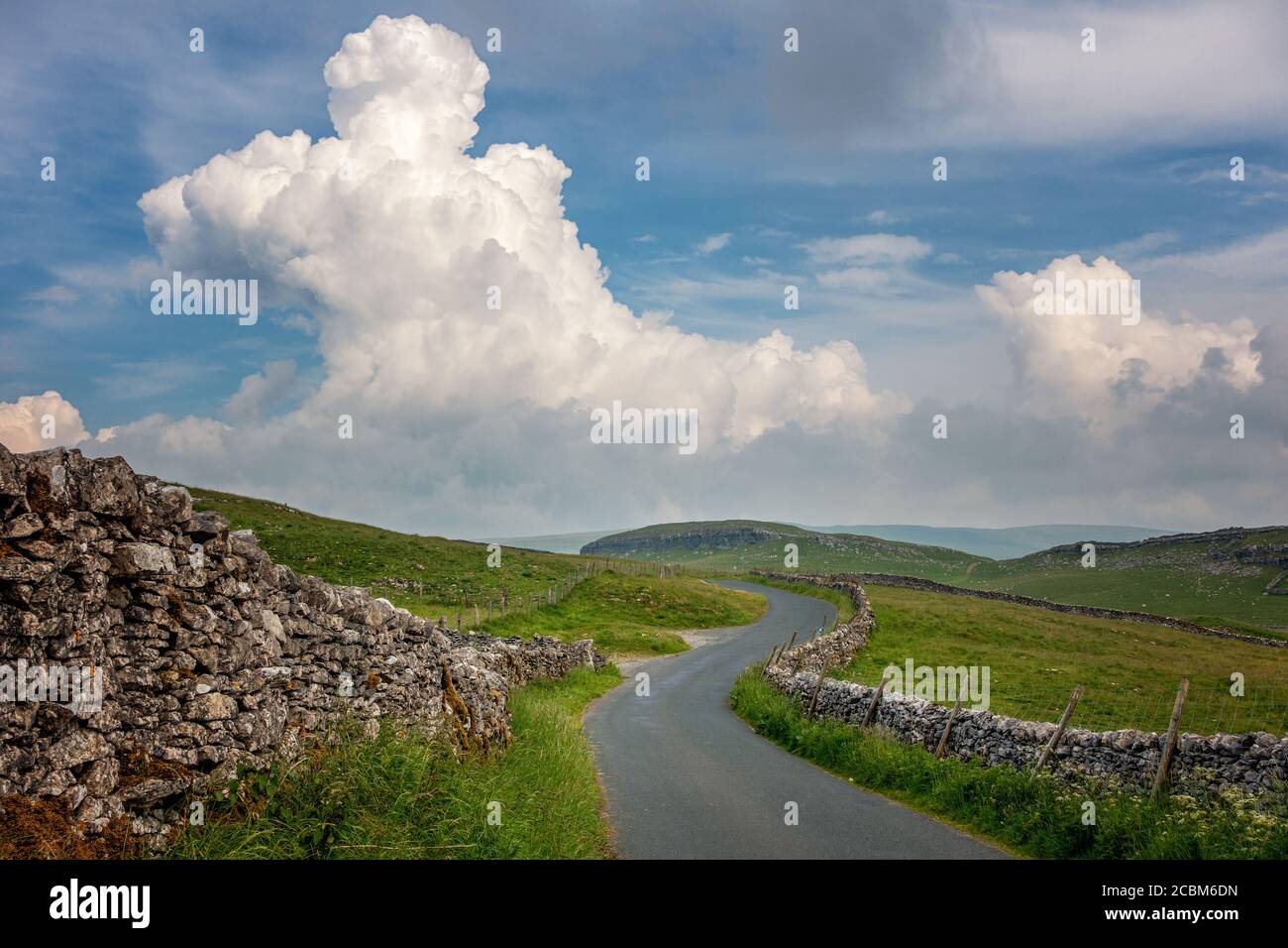 Paysages du Royaume-Uni : route de campagne dans un paysage magnifique dans le parc national de Yorkshire Dales, en direction de Malham Moor avec un bâtiment d'orages Banque D'Images