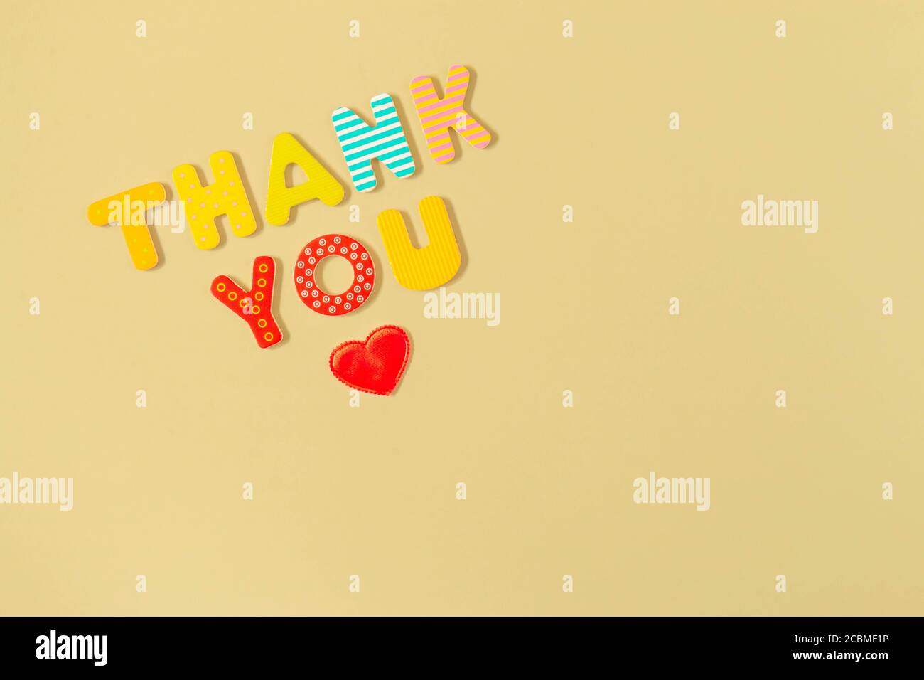 Cœur rouge et mots MERCI de lettres en bois colorées sur fond jaune. Merci inscription et coeur. Reconnaissance, gratitude et amour conce Banque D'Images