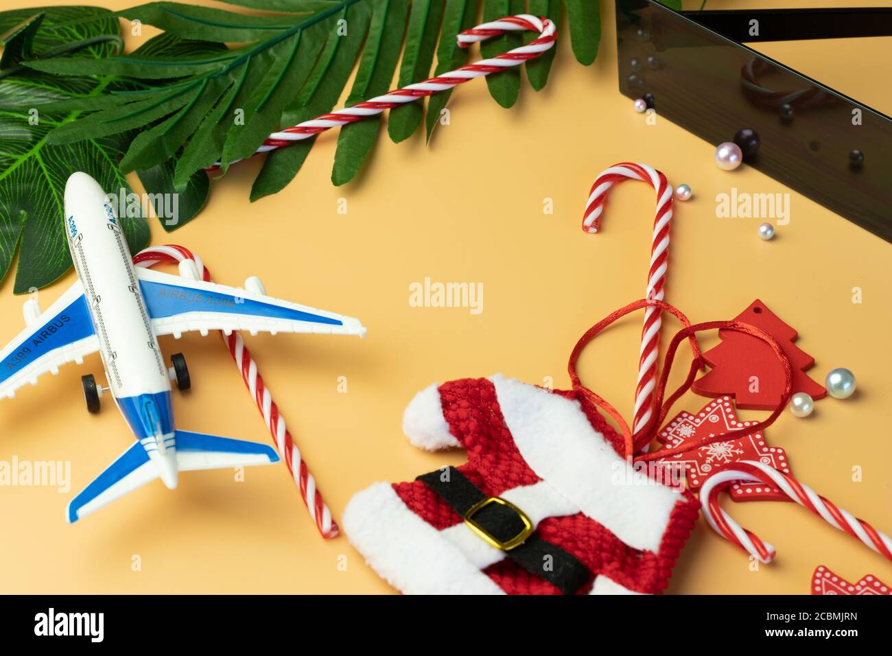 Nouvel an ou saison de Noël voyage tourisme plat lay. Vue de dessus des décorations de week-end et de vacances. Arrière-plan orange. Banque D'Images