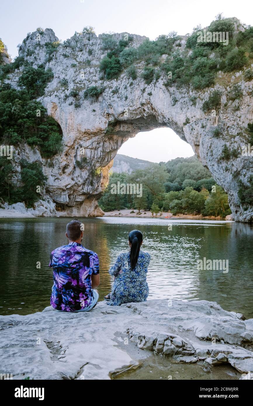 Couple sur la plage au bord de la rivière dans l'Ardèche France Pont d'Arc, Ardèche France, vue de l'arche de Narural à Vallon Pont d'Arc dans le canyon d'Ardèche Banque D'Images