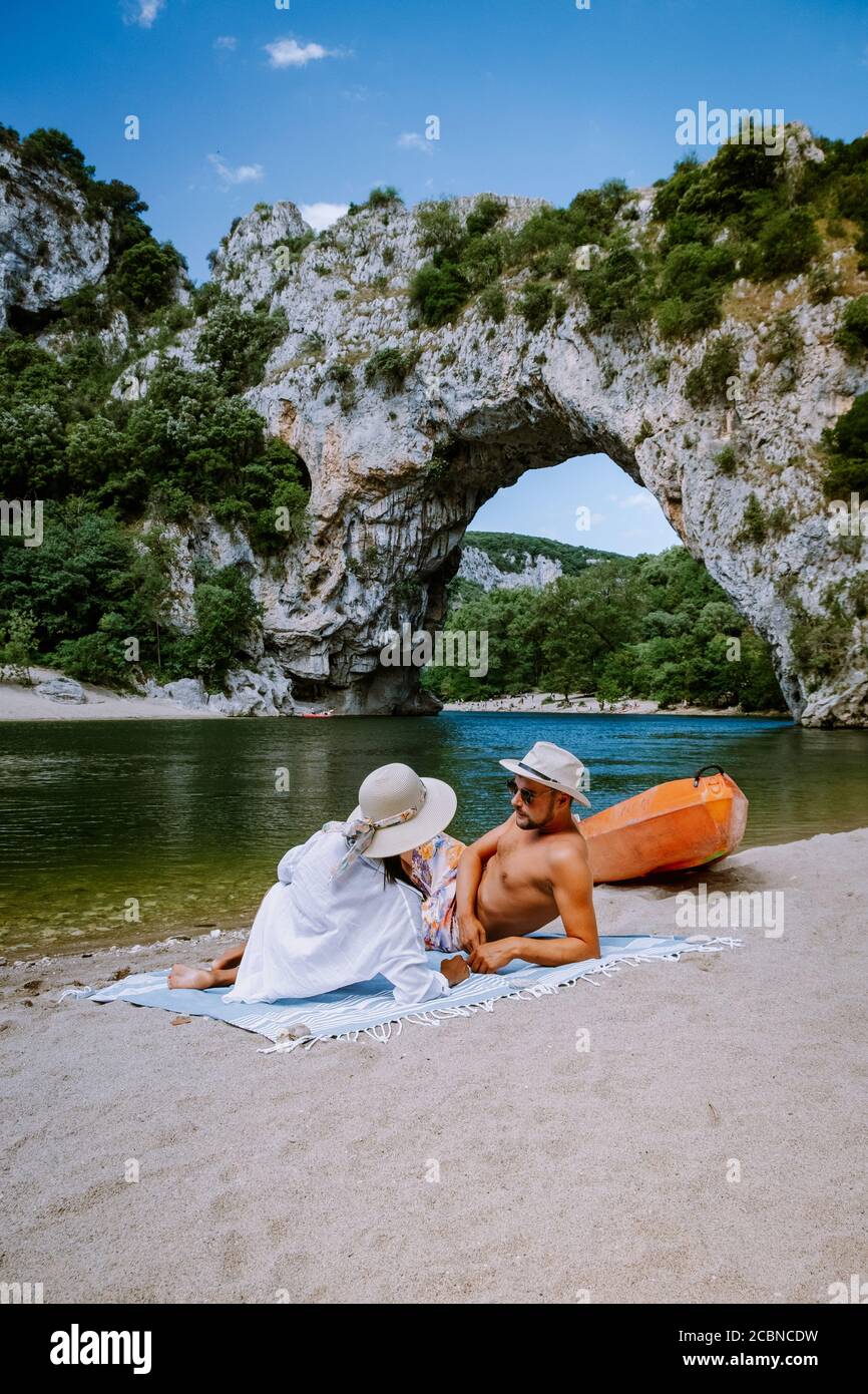 Couple sur la plage au bord de la rivière dans l'Ardèche France Pont d'Arc, Ardèche France, vue de l'arche de Narural à Vallon Pont d'Arc dans le canyon d'Ardèche Banque D'Images