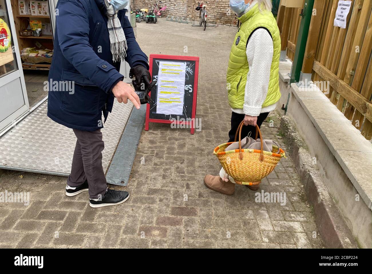 Paris, France - 21 mars 2020 : couple discutant de la distanciation sociale pendant le shopping dans une ferme locale pendant la maladie du coronavirus COVID-19 Banque D'Images