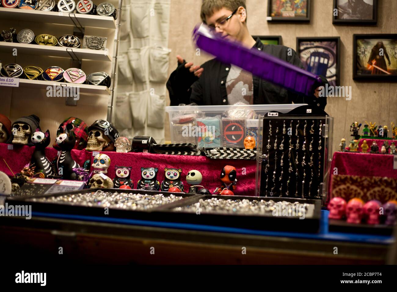 Vendeur de stalle de marché avec des bibelots alternatifs, goth, emo, hipster, squelettes, bijoux, figurines, Superman, Dr Who,Kylo Ren,Lego, photographie de rue Banque D'Images