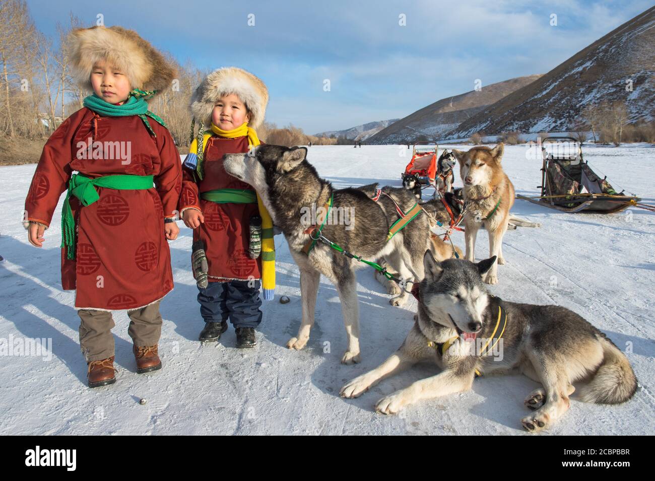 Enfants avec des huskies devant un traîneau à chiens, Terelj, TUV aimag, Mongolie Banque D'Images