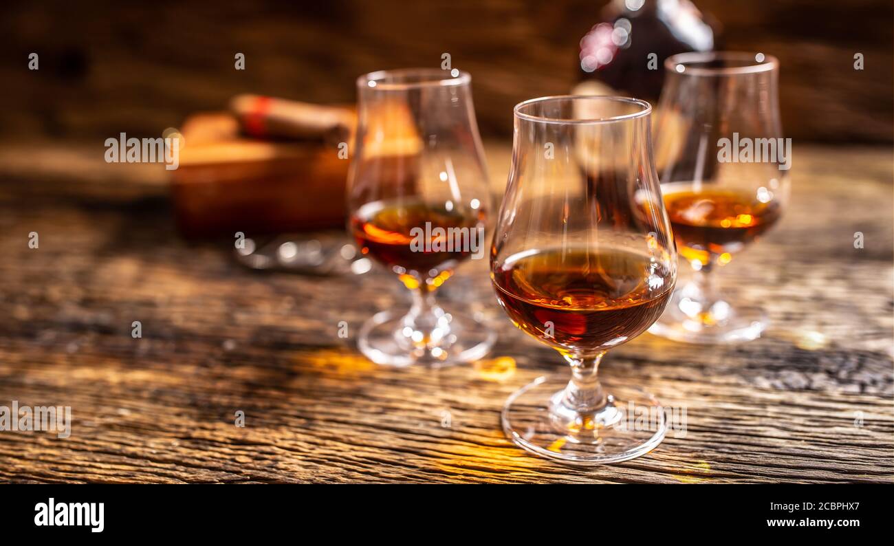 Rhum des Caraïbes dans des verres modernes avec une bouteille de rhum et un cigare en arrière-plan Banque D'Images