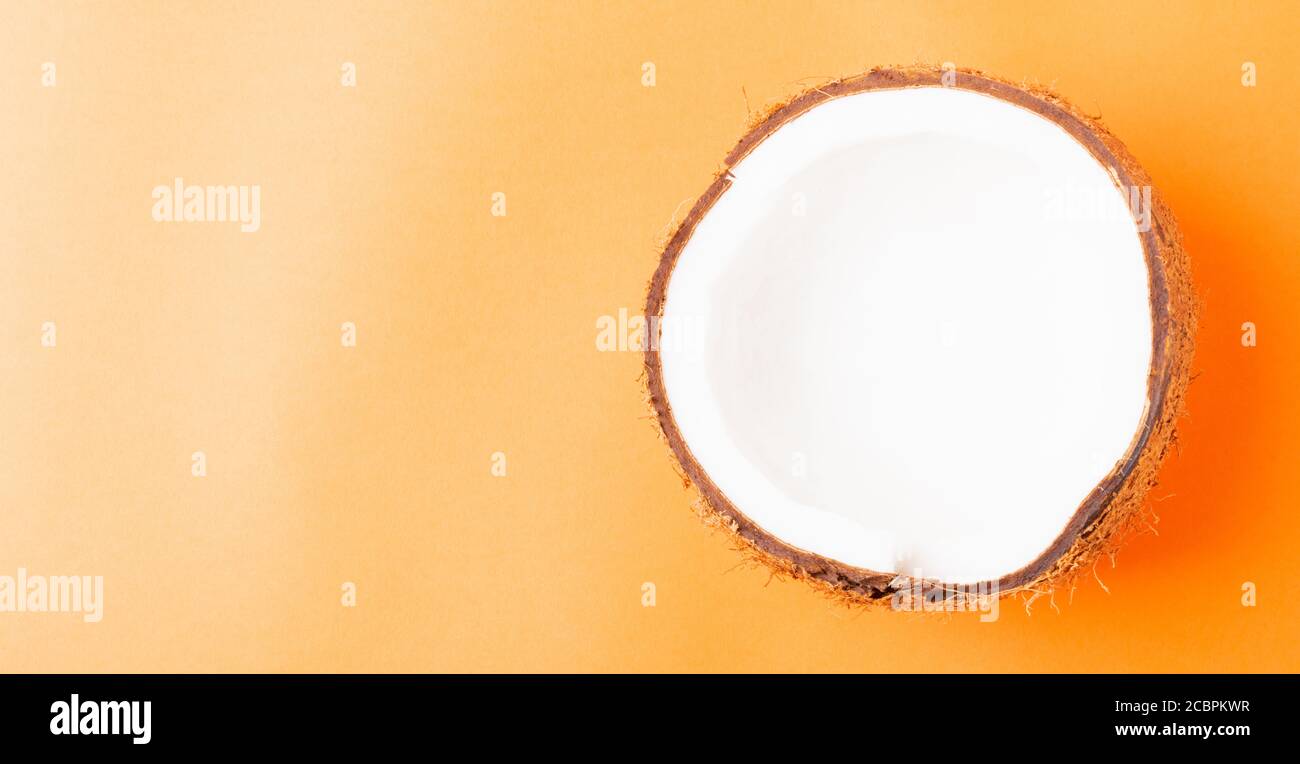 Happy Coconuts Day concept, frais moitié noix de coco, studio tourné isolé sur fond orange Banque D'Images