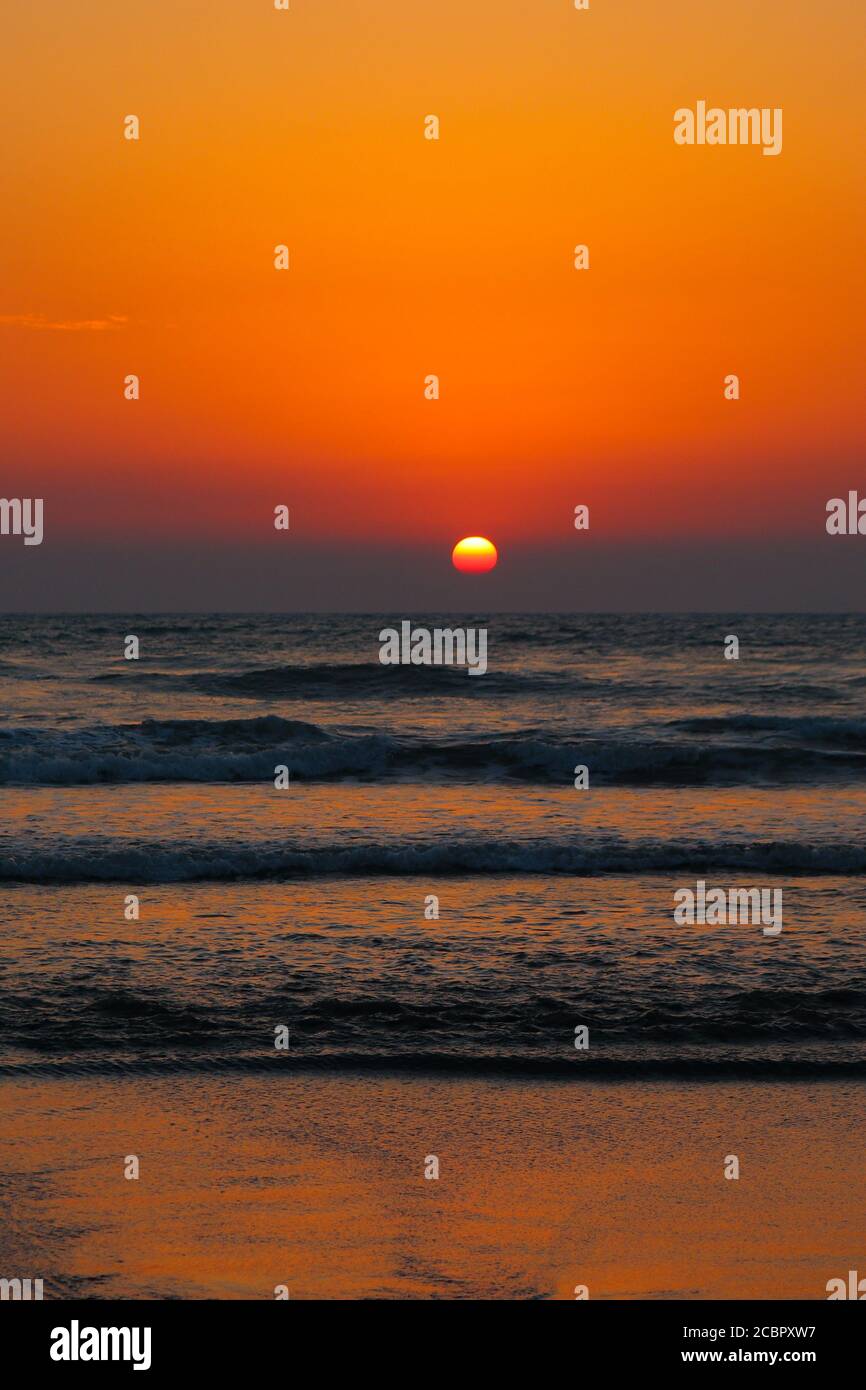 Un beau coucher de soleil sur l'océan bleu avec un ciel coloré qui reflétait la couleur de l'eau. Banque D'Images