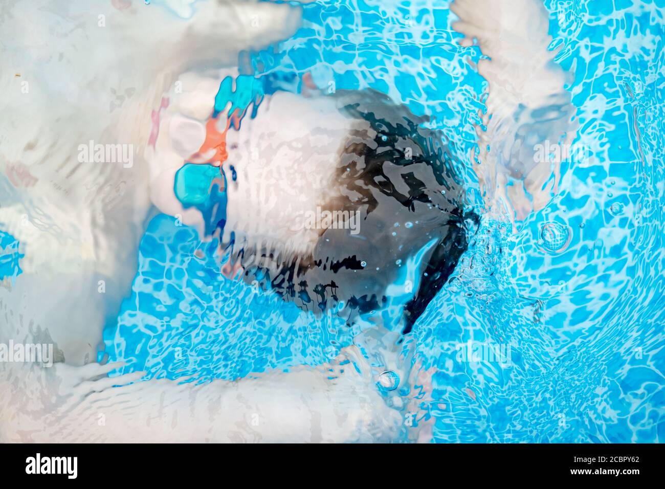 vue de la tête d'un jeune garçon tout en plongeant sous l'eau une piscine pendant une chaude journée d'été Banque D'Images