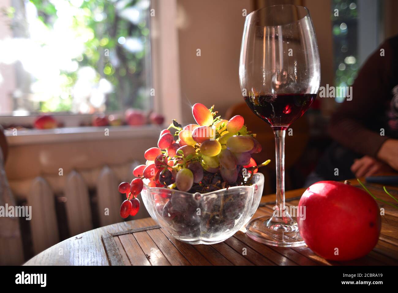 Un vase avec un raisin de table rose et un verre classique de vin rouge Banque D'Images