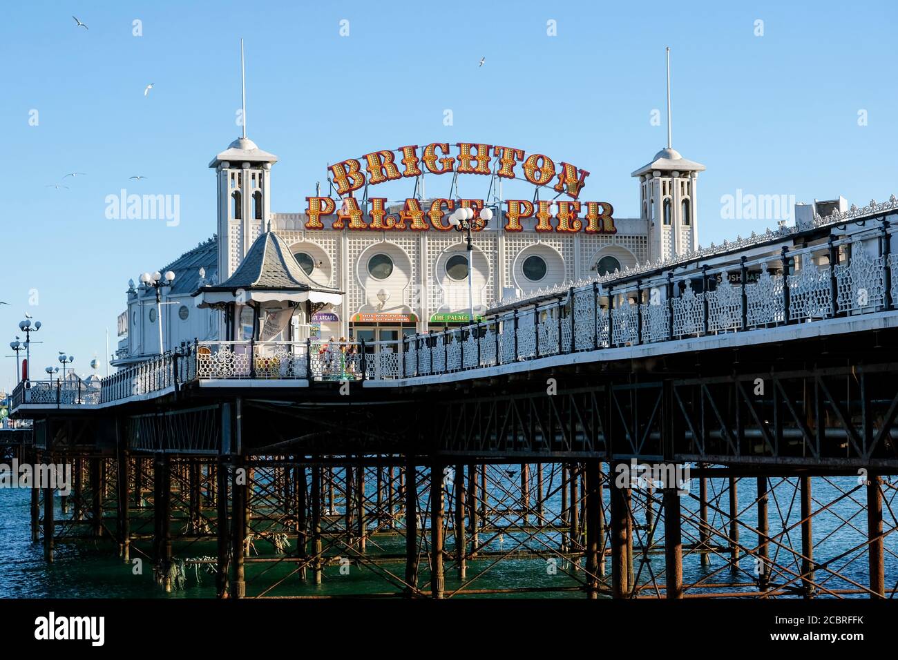 Le Brighton Palace Pier est un point de repère emblématique du front de mer de Brighton. Image prise dans un jour ensoleillé d'été, montrant la mer et quelques mouettes. Banque D'Images