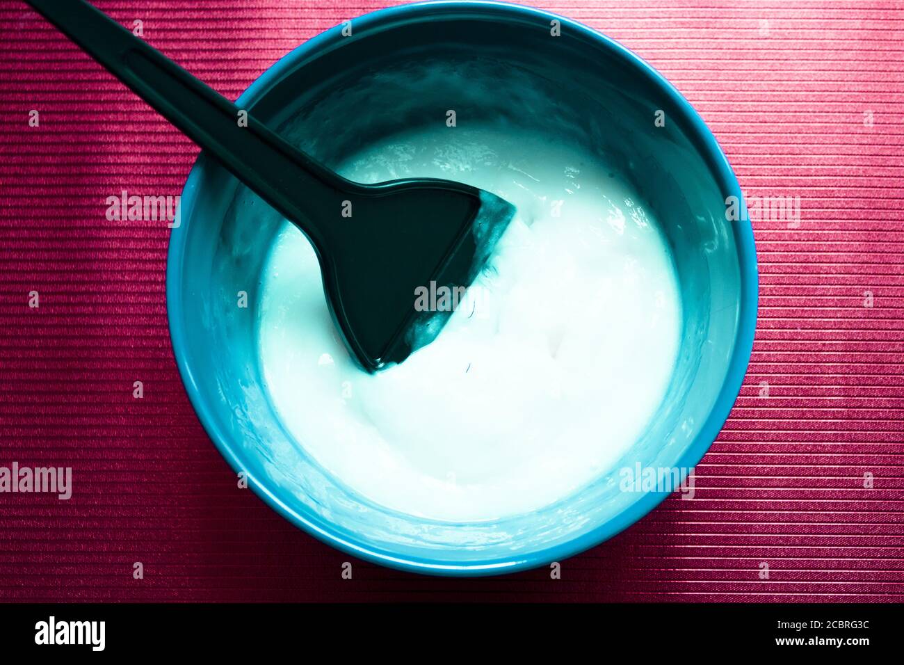 Bol bleu avec mélange pour teindre les cheveux. Palette de colorants à l'intérieur du bol mélangeur Banque D'Images
