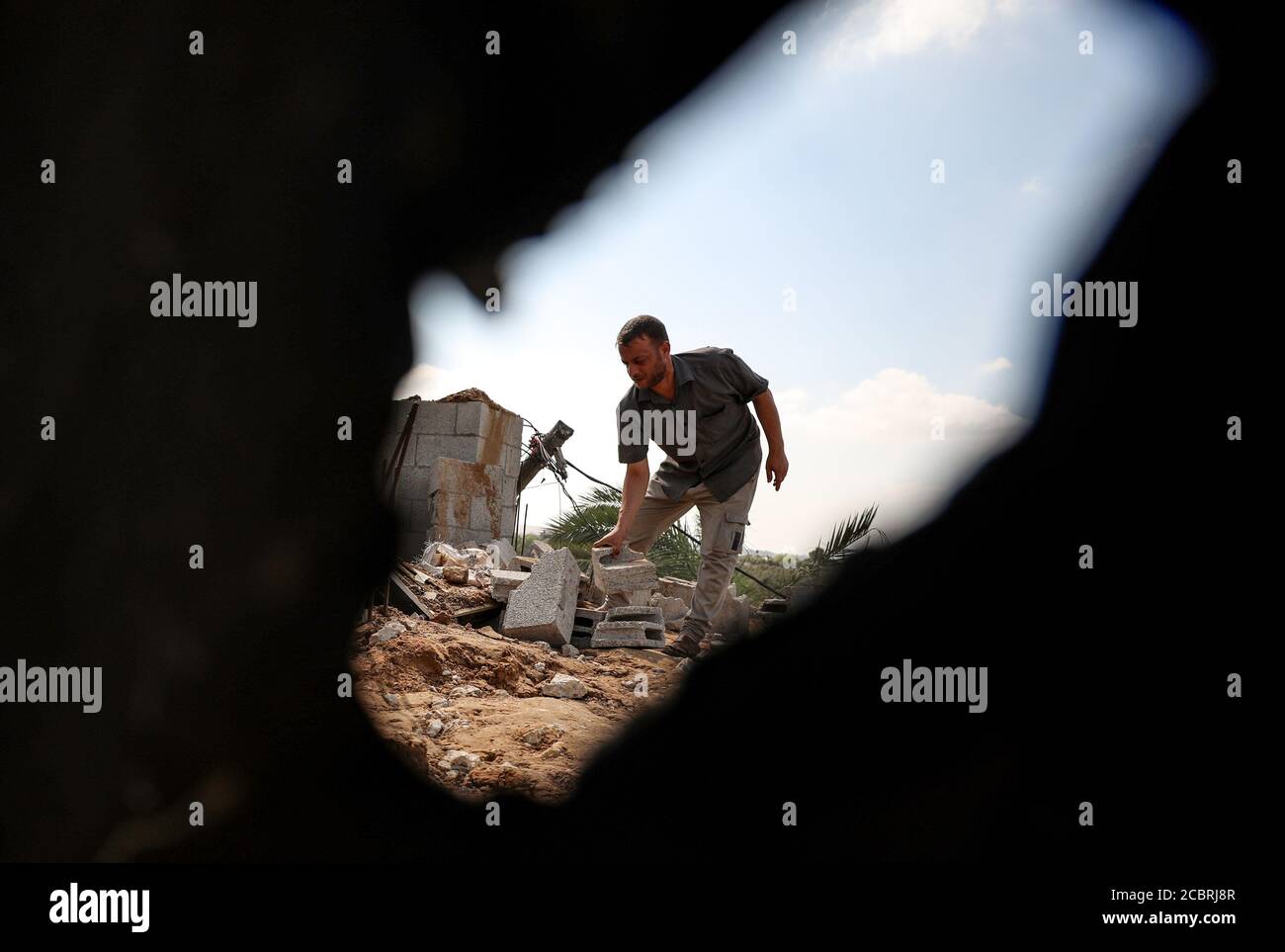 Gaza. 15 août 2020. Un palestinien inspecte les dommages causés à une maison à la suite d'une frappe aérienne israélienne à l'est du camp de réfugiés d'al-Bureij, dans le centre de la bande de Gaza, le 15 août 2020. Des avions de l'armée israélienne ont frappé vendredi soir des postes et des installations dans la bande de Gaza appartenant à des militants du mouvement islamique du Hamas en réponse au lancement de ballons incendiaires depuis l'enclave côtière vers Israël. Credit: Yasser Qudih/Xinhua/Alay Live News Banque D'Images