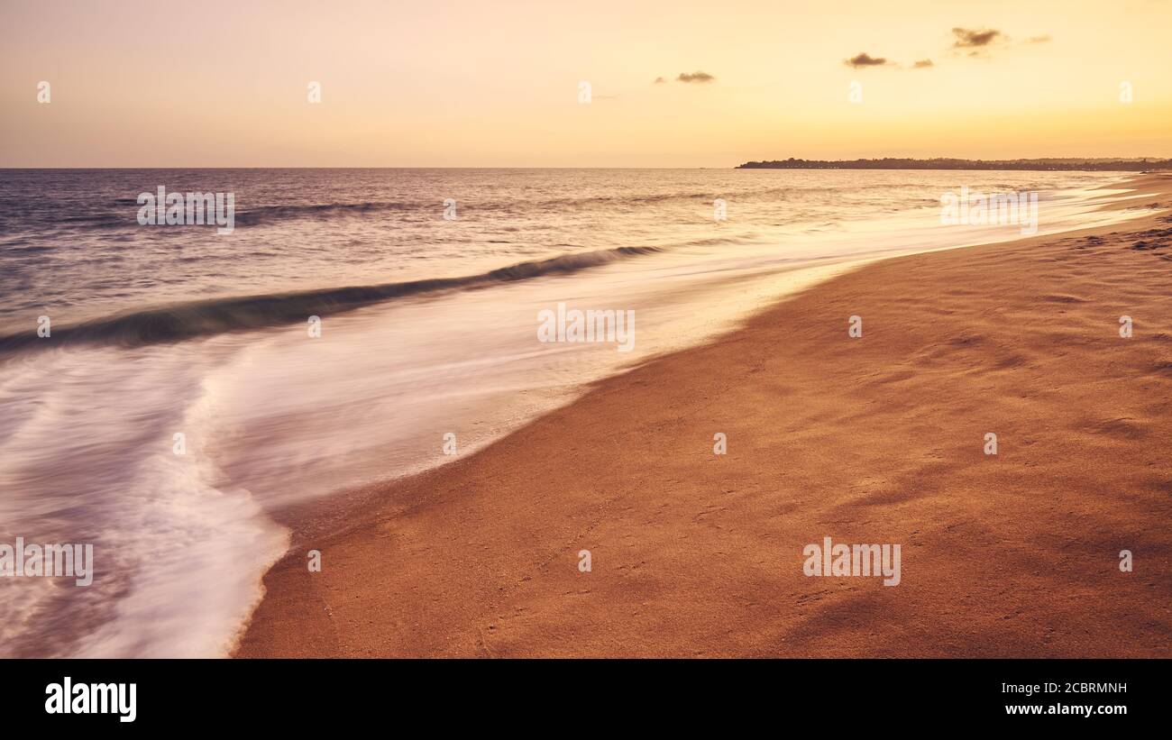 Plage tropicale de sable au coucher du soleil, image longue exposition, concept de vacances d'été, couleurs appliquées. Banque D'Images