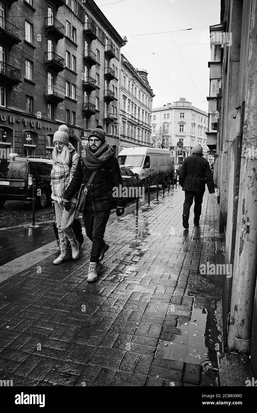 Marcher ensemble. Lviv/Ukraine - 30 janvier 2020 : couple tenant les mains marchant dans la rue Akademika Hnatyuka Banque D'Images