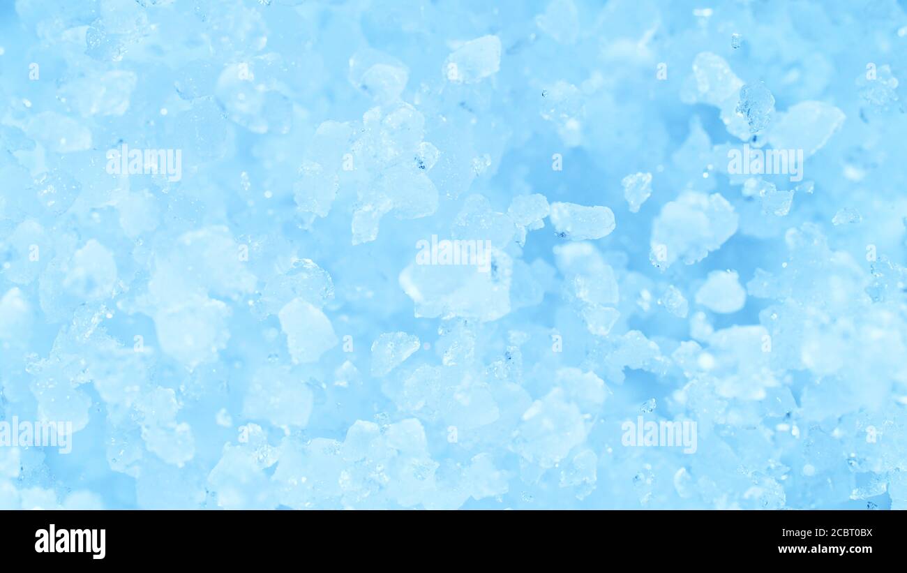 Explosion de glace pilée sur fond bleu. Geler le mouvement des morceaux de glace volants. Banque D'Images