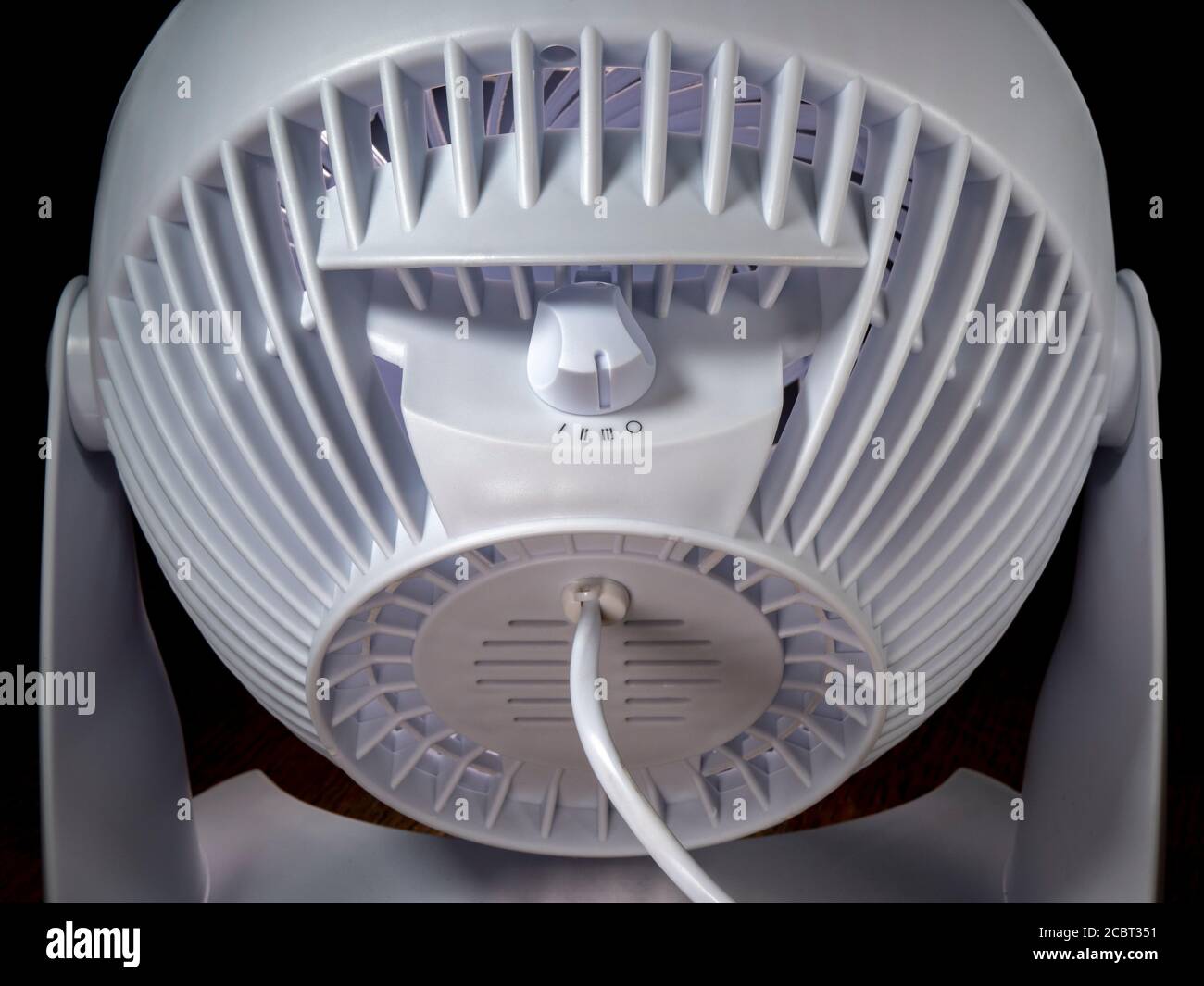 Gros plan sur l'arrière d'un ventilateur de bureau moderne, en plastique blanc, activé via le bouton de commande à la vitesse la plus élevée. Banque D'Images