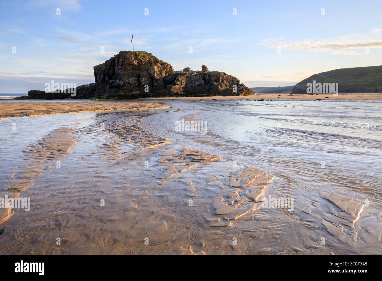 Chapel Rock sur la plage de Perranporth à Cornwall capturé un matin à la mi-juillet avec des motifs de sable comme intérêt de premier plan. Banque D'Images