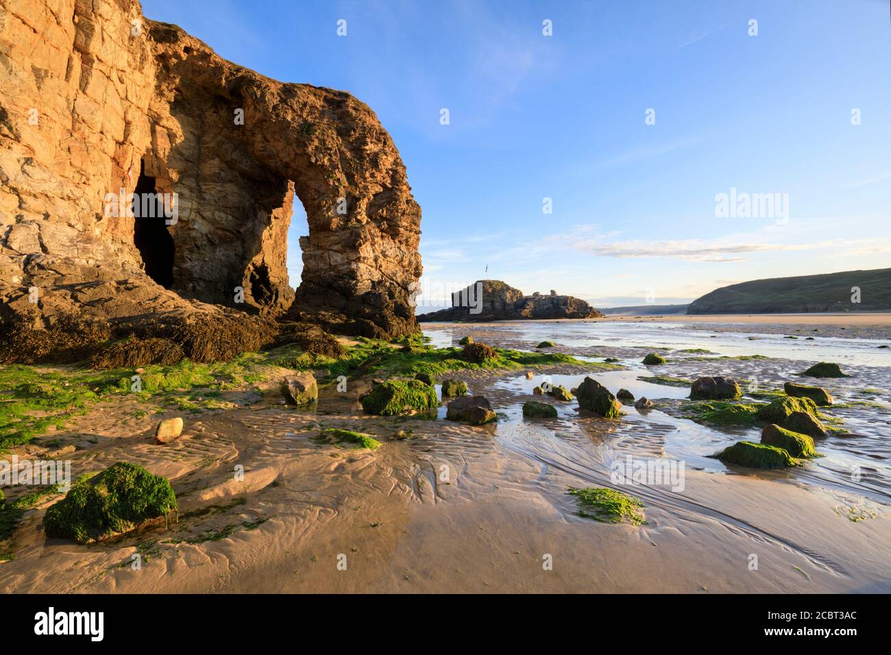 L'arche de mer naturelle et Chapel Rock sur la plage de Perranporth à Cornwall ont été capturés un matin à la mi-juillet avec des motifs de sable comme intérêt de premier plan. Banque D'Images