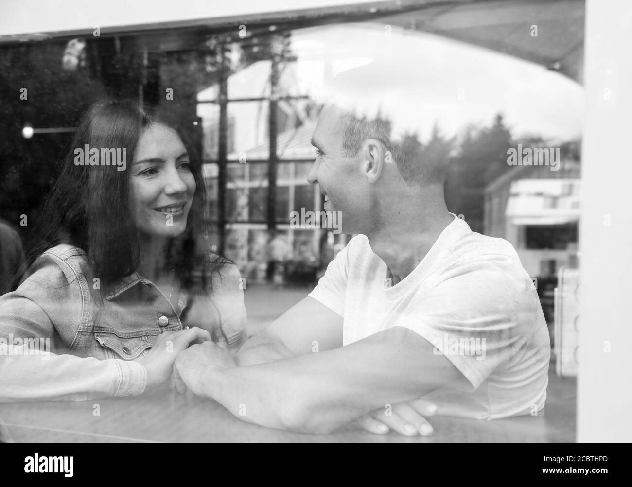 Un jeune couple se fait un plaisir de se détendre au café-restaurant. Image noir et blanc - mise au point sélective. Banque D'Images