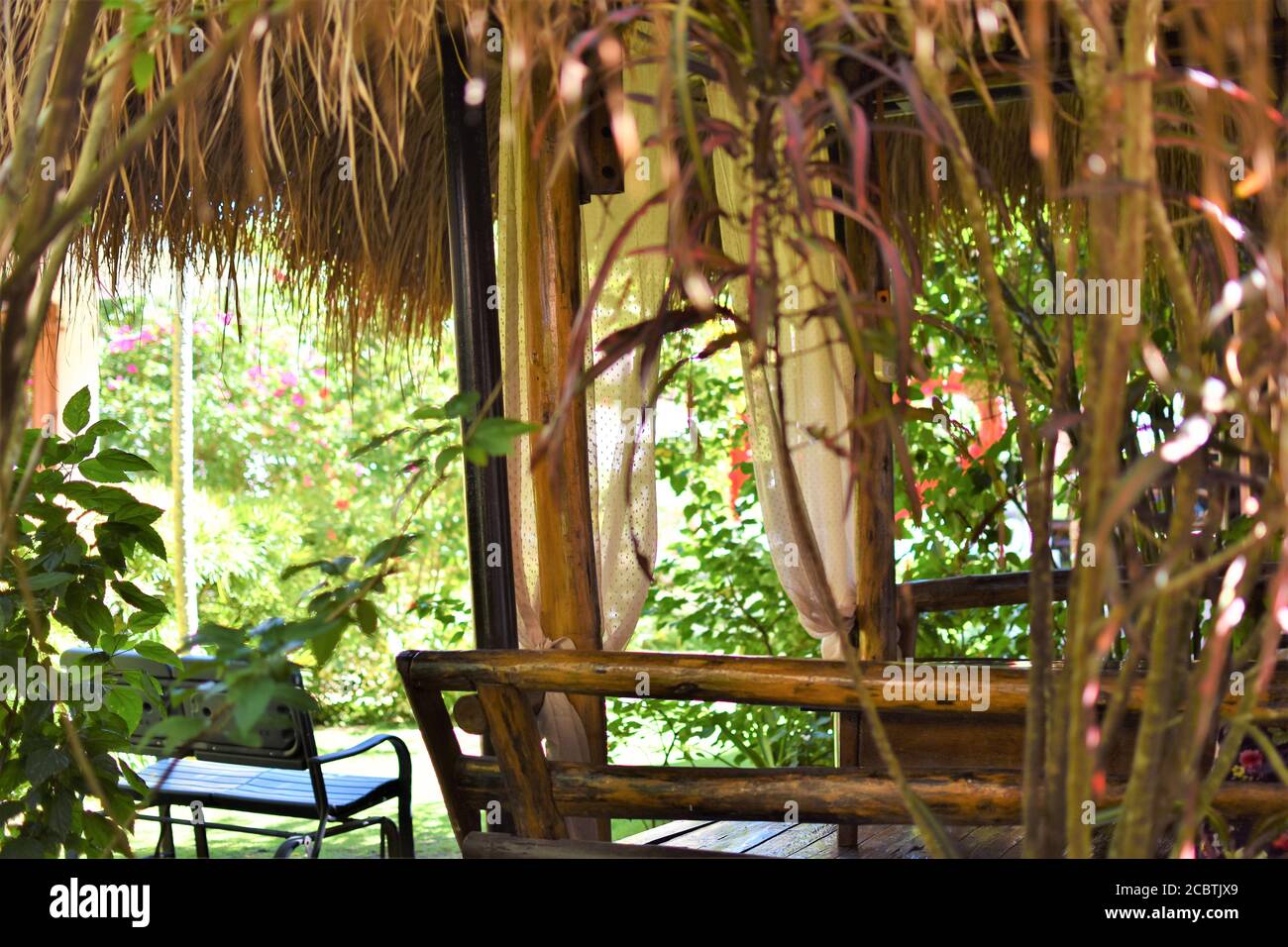 Un jardin relaxant avec un banc et un belvédère indigène en nipa et bambou Banque D'Images