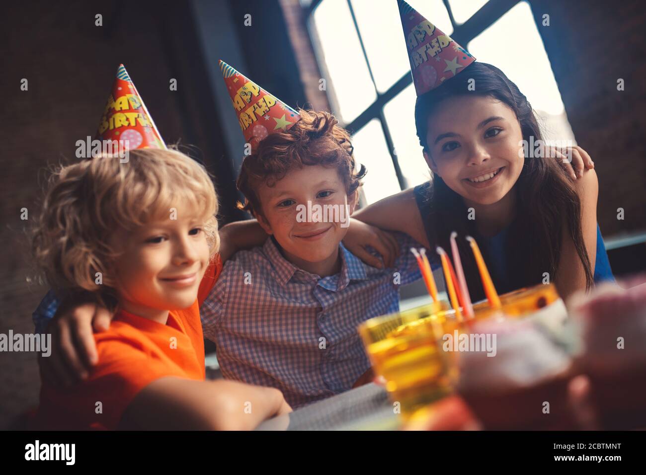 Trois enfants fêtent leur fête et sourient bien Banque D'Images