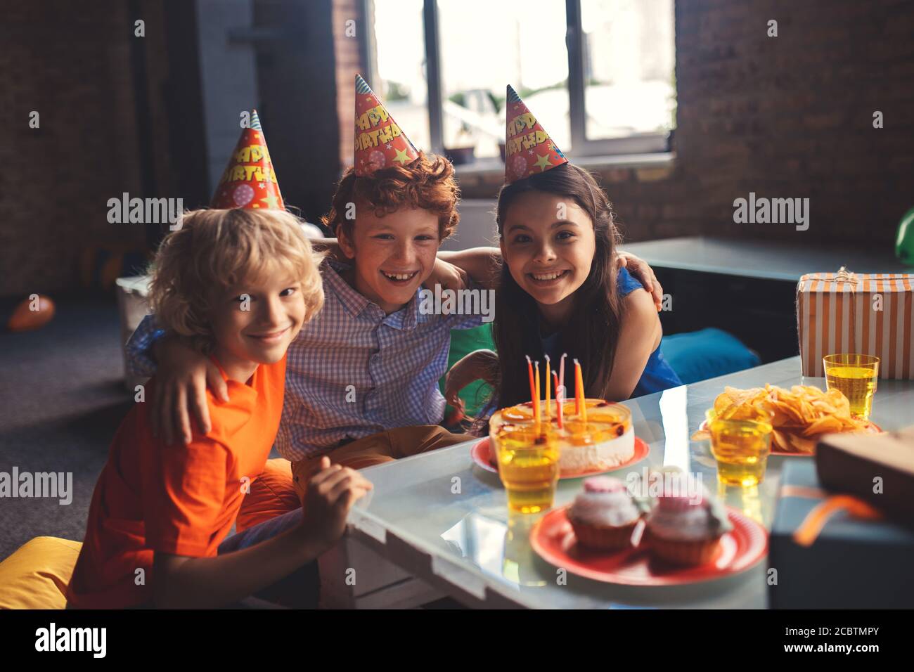 Trois enfants fêtent leur fête et se sentent merveilleux Banque D'Images