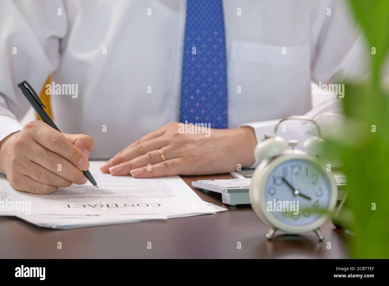 Homme d'affaires en activité et réveil blanc. Concept temps de travail. Banque D'Images