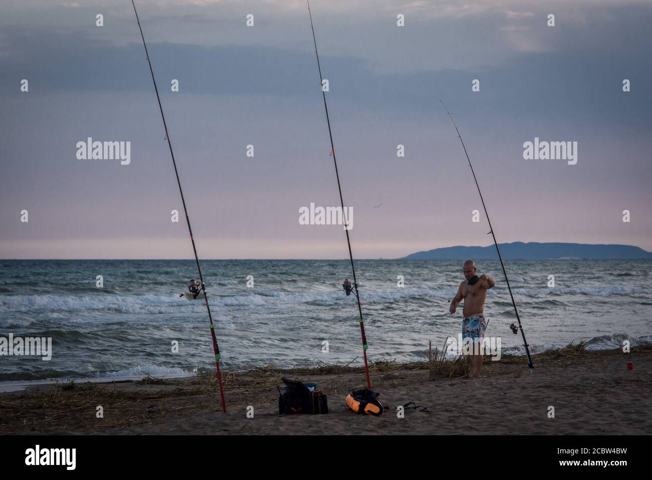 Le pêcheur prépare les cannes à pêche à la plage du Delta de l'Ebre Eucaliptus à Tarragone, en Catalogne, en Espagne Banque D'Images