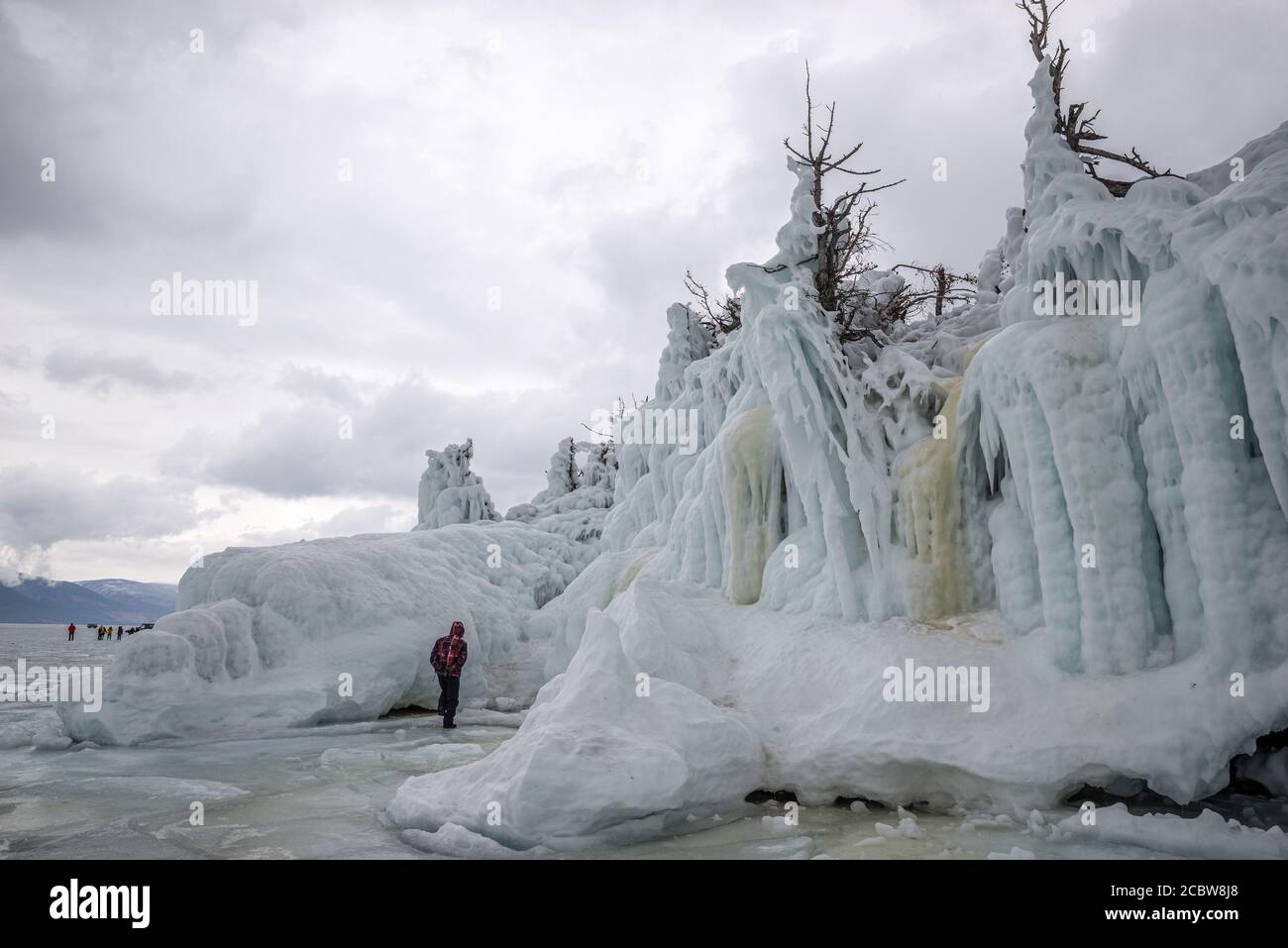 Un touriste parmi les arbres et les rochers couverts de glace, lac Baikal, Russie Banque D'Images