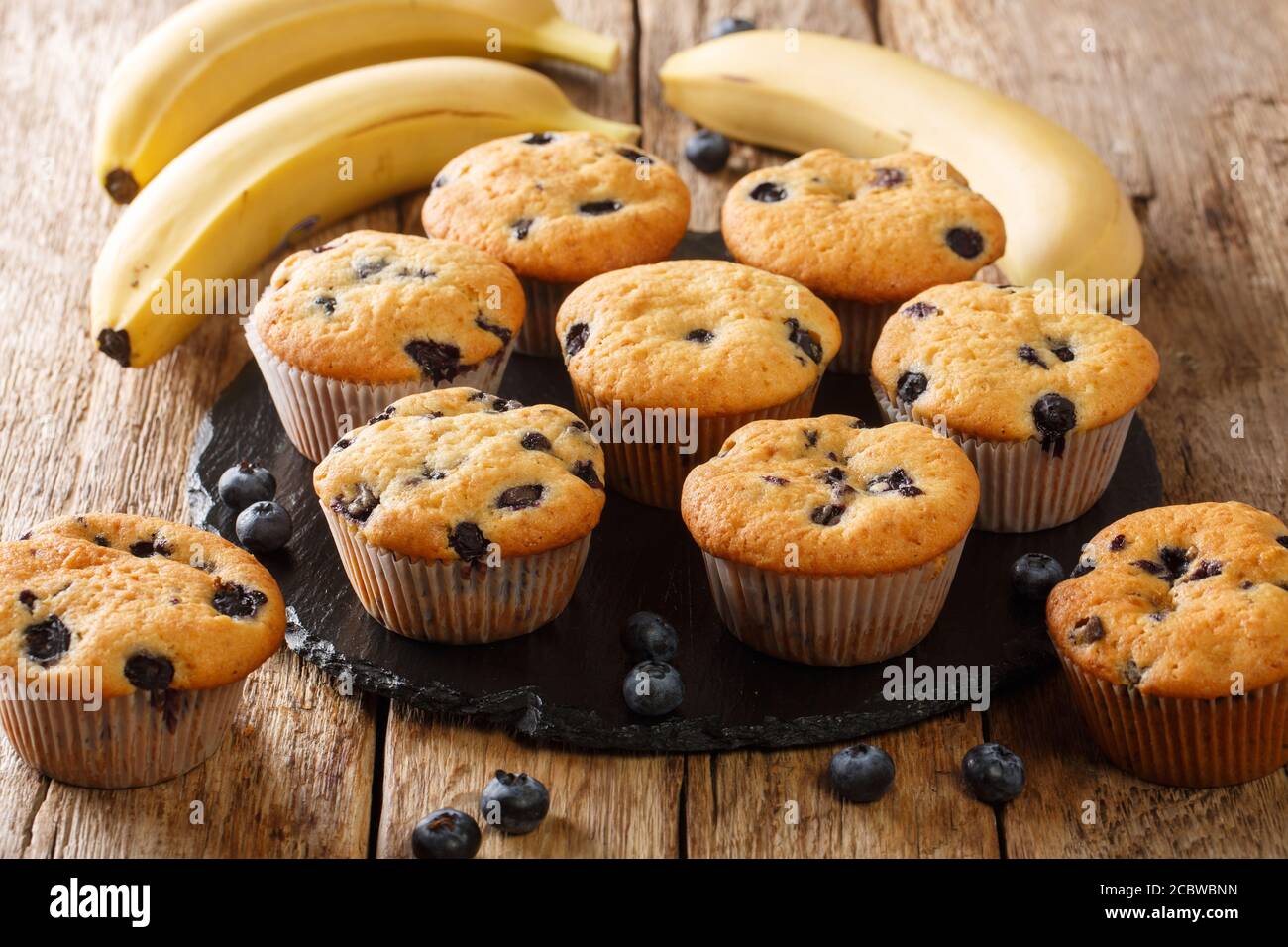 Des muffins faits maison avec des myrtilles et des bananes en gros plan sur un tableau d'ardoise sur la table. Horizontal Banque D'Images