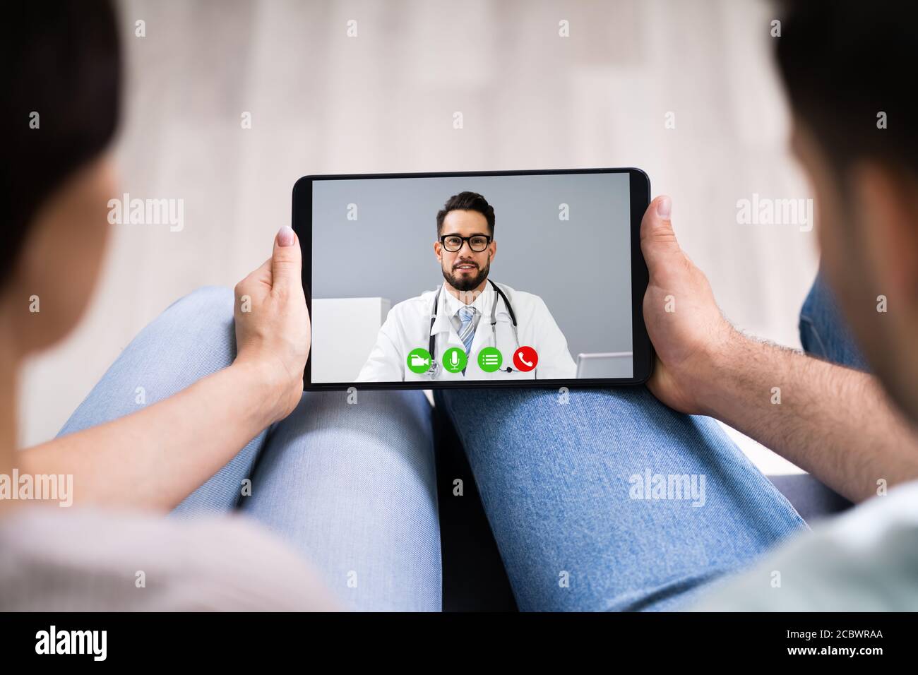 Couple enceinte en appel de vidéoconférence en ligne avec le médecin Banque D'Images