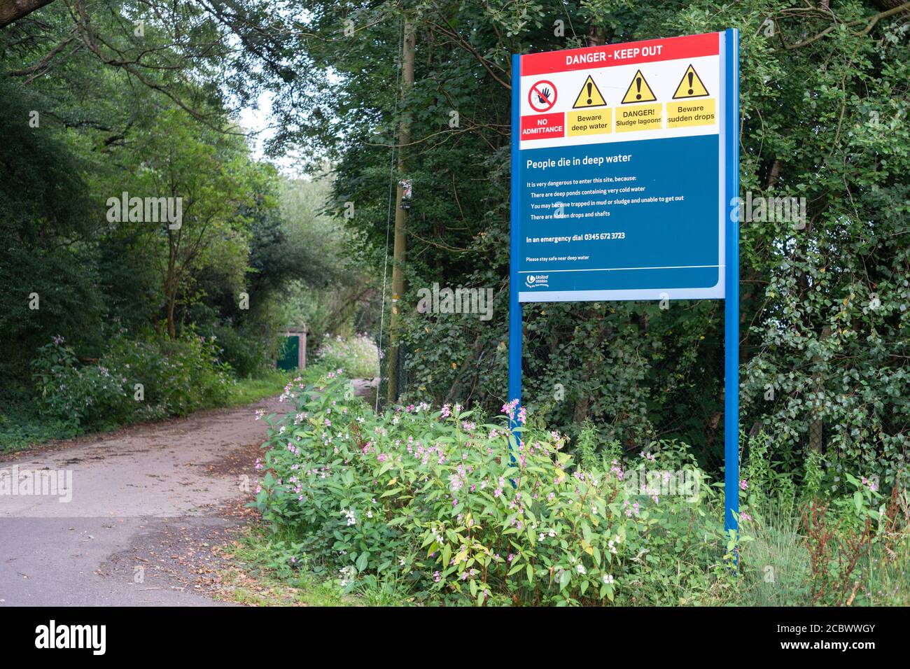 Signez avec divers avertissements de danger près d'une installation de traitement d'eau United Utilities sur Red Rock Lane, Stoneclough, Angleterre, Royaume-Uni Banque D'Images