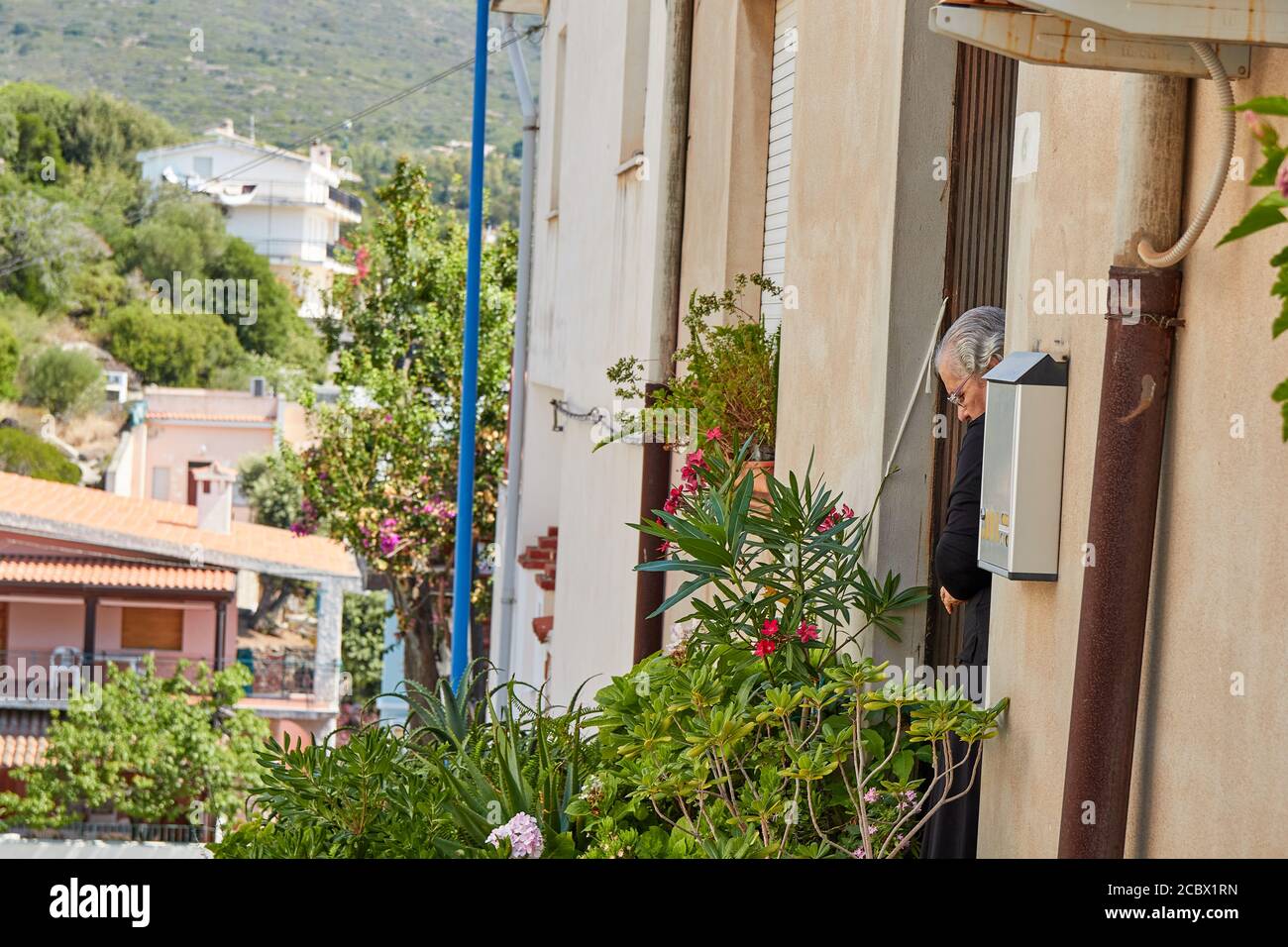 Une femme d'âge mûr qui nettoie l'entrée à la maison multiple Banque D'Images