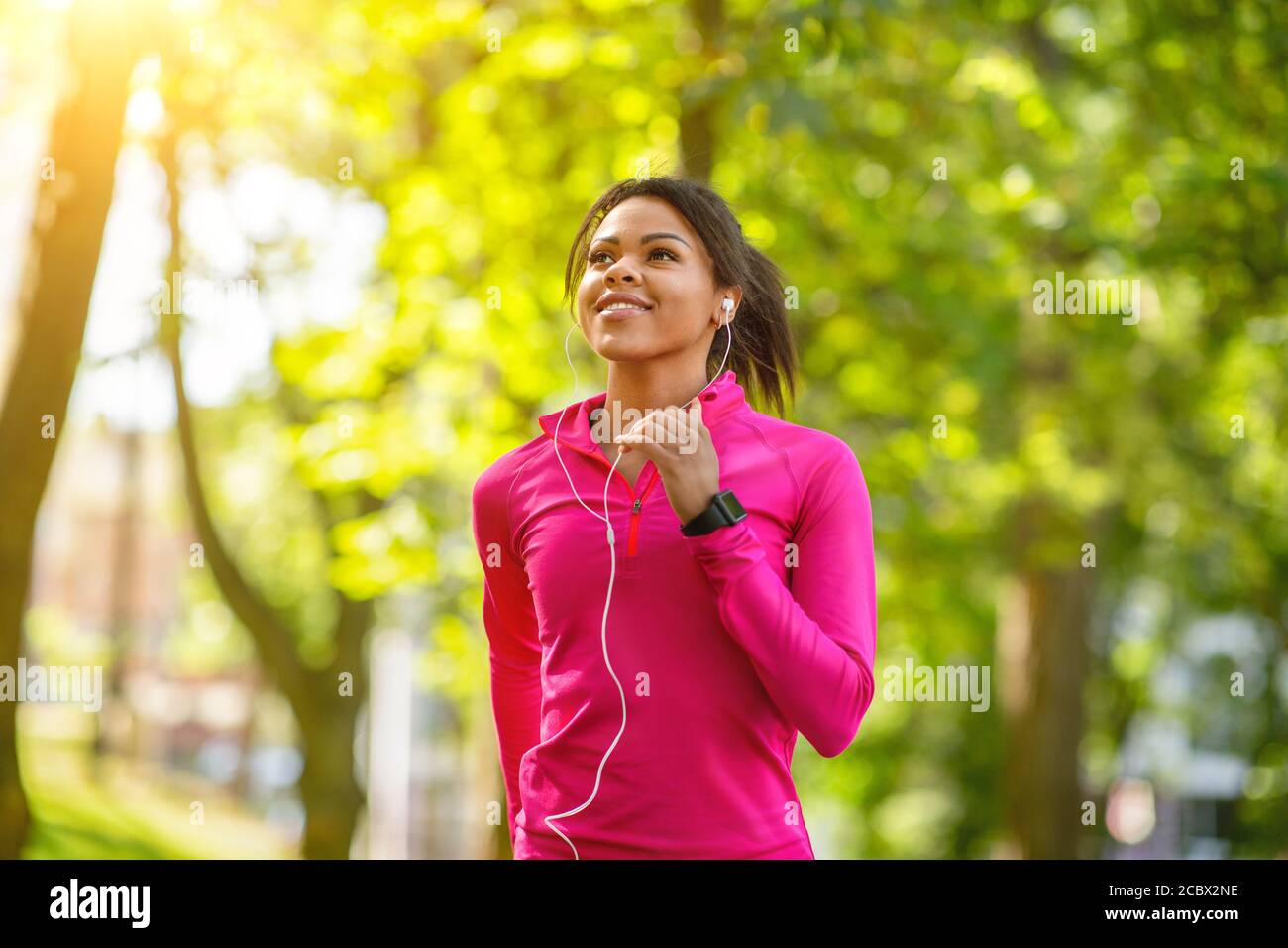 Joyeux entraînement de jogging de fille africaine dans le parc public Banque D'Images