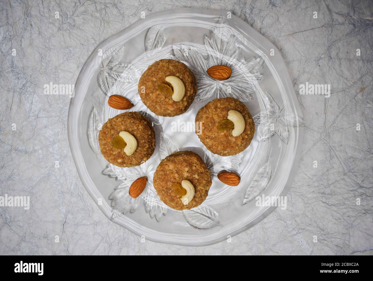 Vue de dessus de Laddu, ladoos Indian Sweet Balls sur une assiette de vaisselle transparente décorée d'amandes et de noix de cajou. Pour des festivals comme Ganesh chaturthi Banque D'Images