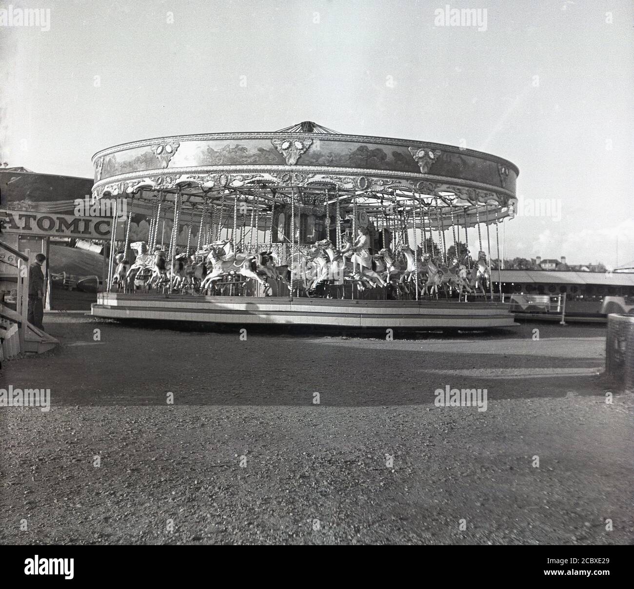Années 1950, historique, vue d'un manège funfair carrousel, montrant des chevaux galopants sur une plate-forme circulaire tournante, avec un tour à cette époque coûtant 6d ...in vieux argent, Angleterre, Royaume-Uni. Ces manèges sont également connus sous le nom de manèges ou manèges. Banque D'Images
