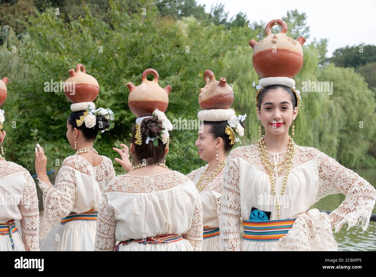 Un groupe de danseurs folkloriques paraguayens américains qui équilibrent de petites citernes sur leur tête. À Flushing, Queens, New York. Banque D'Images