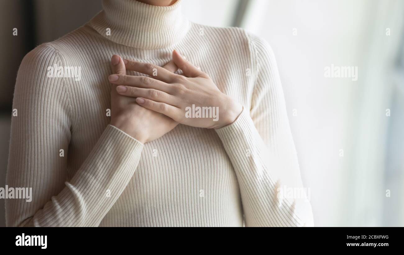 Gros plan sur les mains des femmes, plié sur la poitrine. Banque D'Images