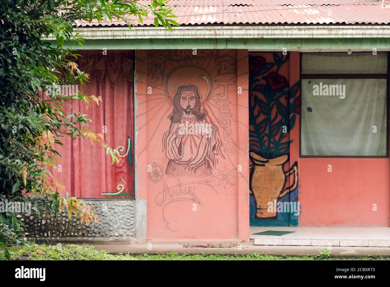 Une murale représentant Jésus sur une maison Bribri indigène dans le village de Suretka, province de Limón, Costa Rica. Banque D'Images