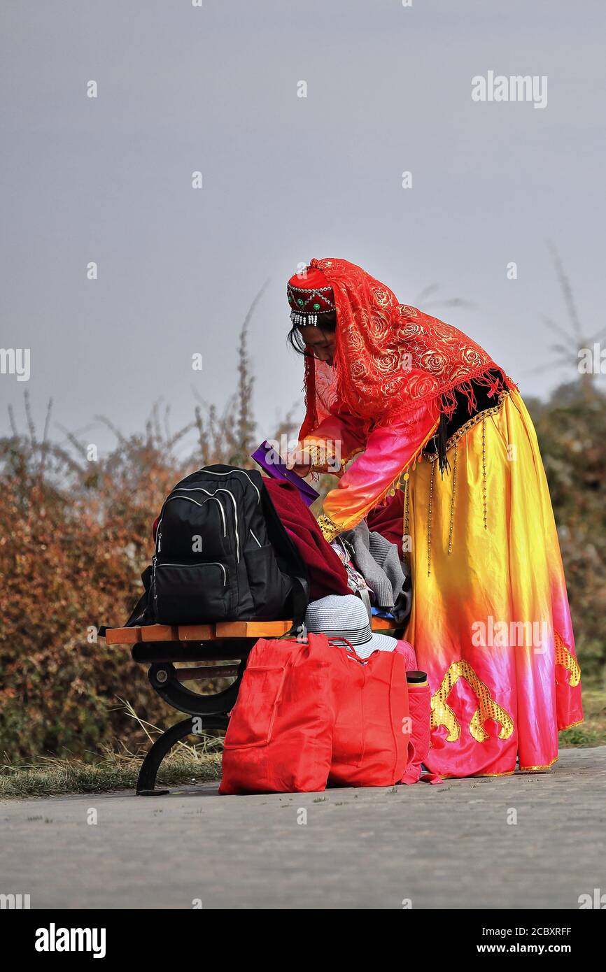 Chapeau de femme Yugur-ethnique en tenue de chambre-terai absorbé dans la commande de bagages. Complexe MatiSi-Zhangye-Gansu-Chine-1012 Banque D'Images